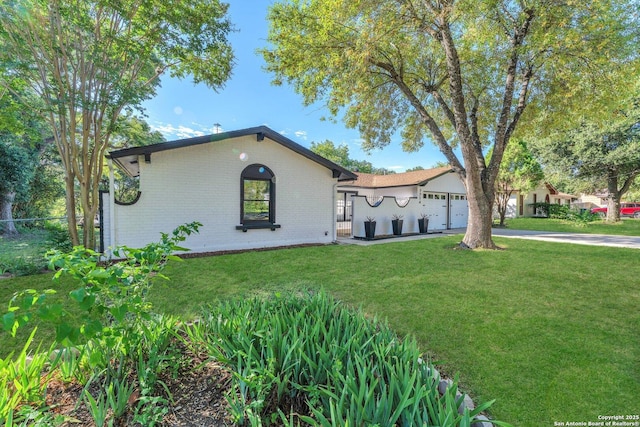 view of front of property featuring brick siding, concrete driveway, a front yard, and a garage