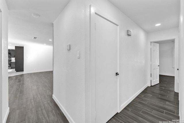 hallway featuring visible vents, recessed lighting, baseboards, and wood tiled floor