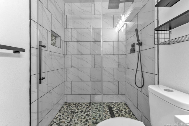 full bathroom with toilet, a stall shower, and a textured wall