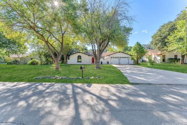 ranch-style house featuring a garage, driveway, and a front lawn