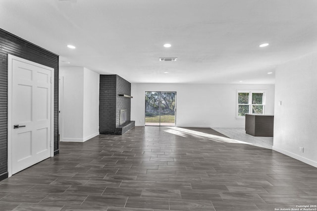 unfurnished living room featuring recessed lighting, visible vents, plenty of natural light, and a fireplace