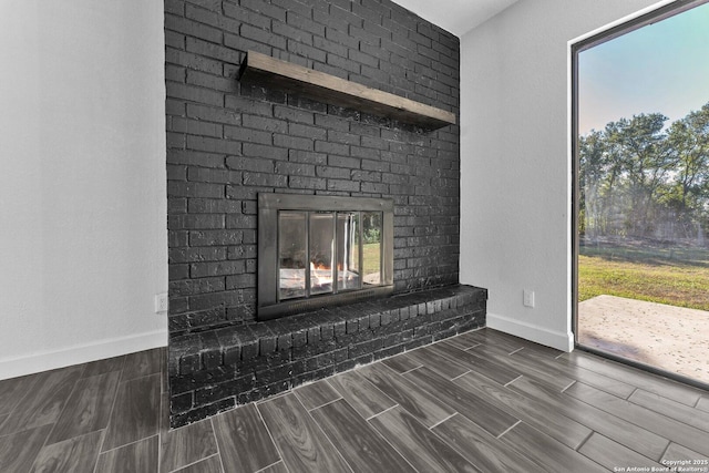 room details featuring wood finish floors, baseboards, and a brick fireplace