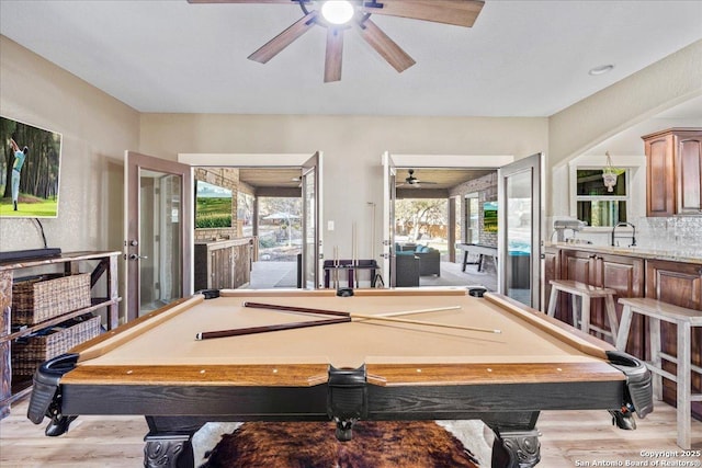 rec room with a wealth of natural light, ceiling fan, and wood finished floors