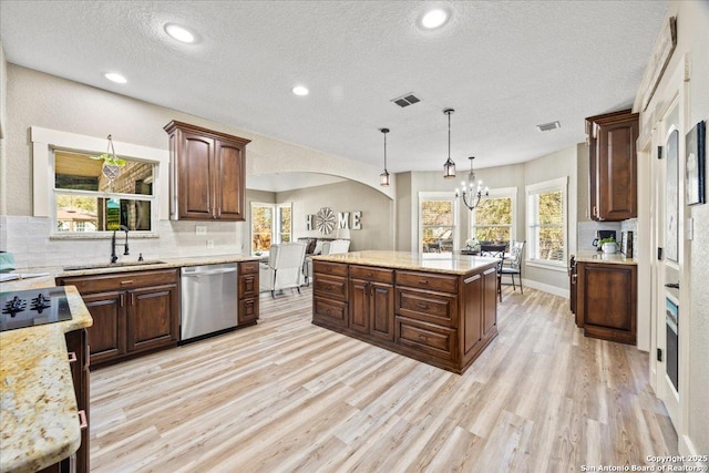 kitchen featuring a sink, stainless steel dishwasher, arched walkways, light wood finished floors, and decorative backsplash