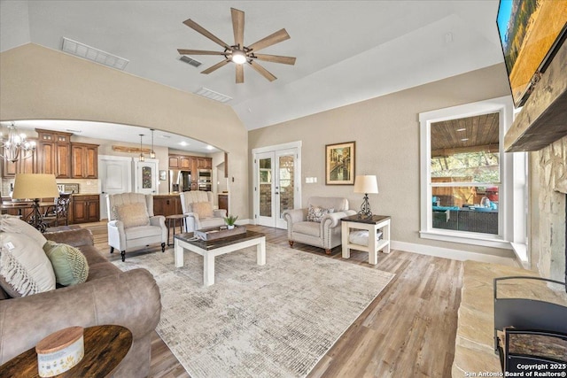 living area with visible vents, lofted ceiling, and french doors