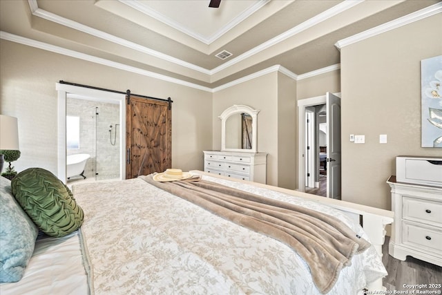 bedroom with visible vents, connected bathroom, crown molding, a barn door, and a raised ceiling