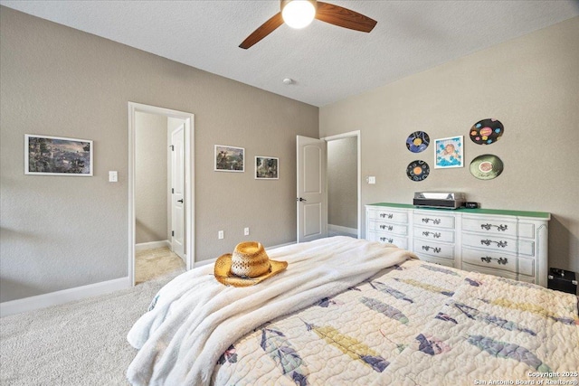 bedroom featuring baseboards, light carpet, a textured ceiling, and ceiling fan