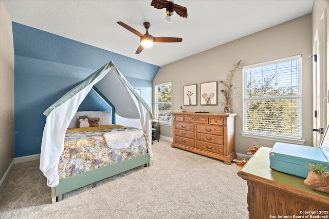 carpeted bedroom with baseboards, lofted ceiling, and a ceiling fan