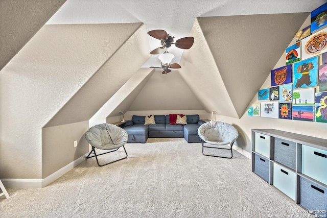 living area featuring vaulted ceiling, carpet flooring, baseboards, and a textured ceiling