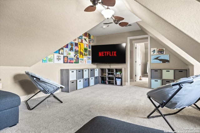 recreation room with visible vents, a ceiling fan, carpet flooring, and vaulted ceiling