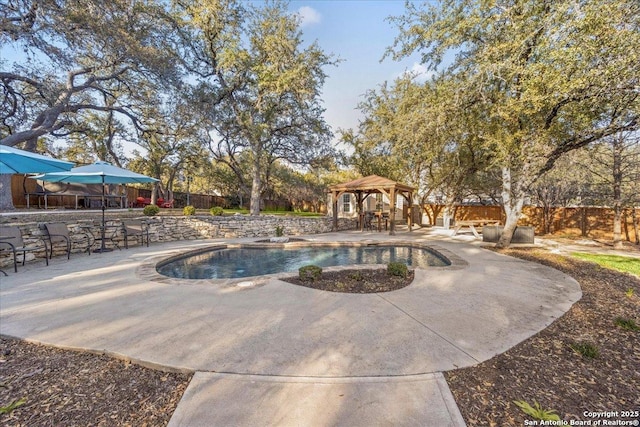 outdoor pool featuring a gazebo, a patio, and fence