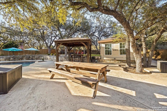 view of patio featuring a fenced in pool, fence, a gazebo, an outdoor structure, and outdoor dining space