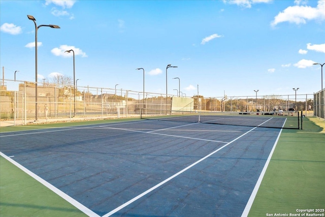 view of tennis court featuring fence