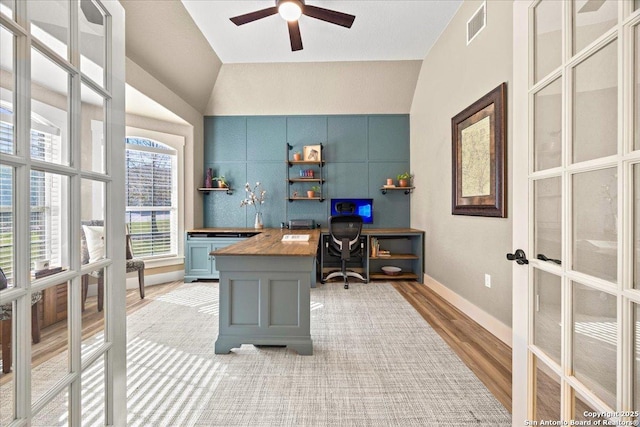 home office featuring french doors, lofted ceiling, visible vents, and light wood finished floors