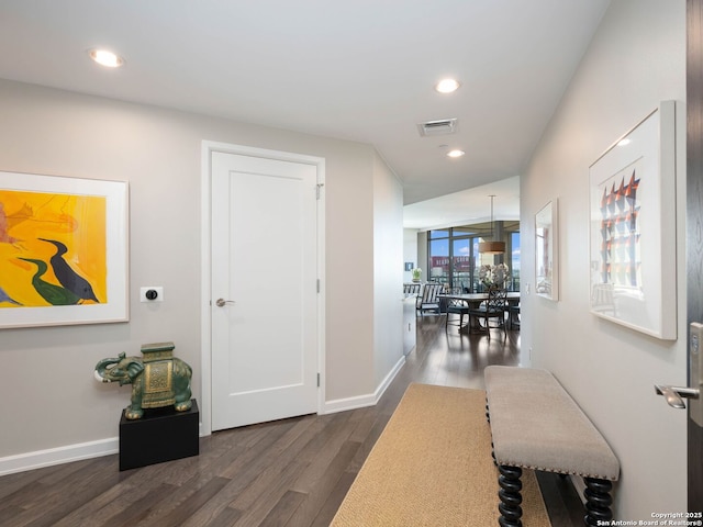 hall featuring recessed lighting, visible vents, baseboards, and dark wood-style floors