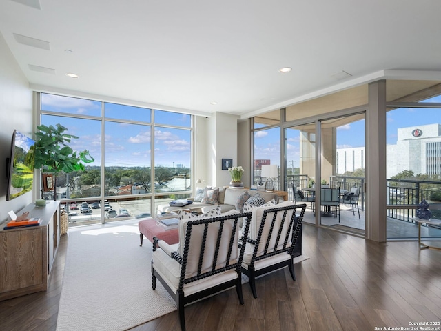 living area with dark wood finished floors, plenty of natural light, and expansive windows