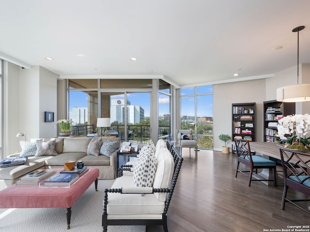 living area with recessed lighting, a view of city, wood finished floors, and floor to ceiling windows