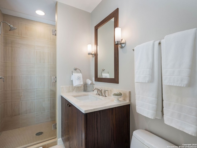 full bathroom featuring vanity, a shower stall, and toilet