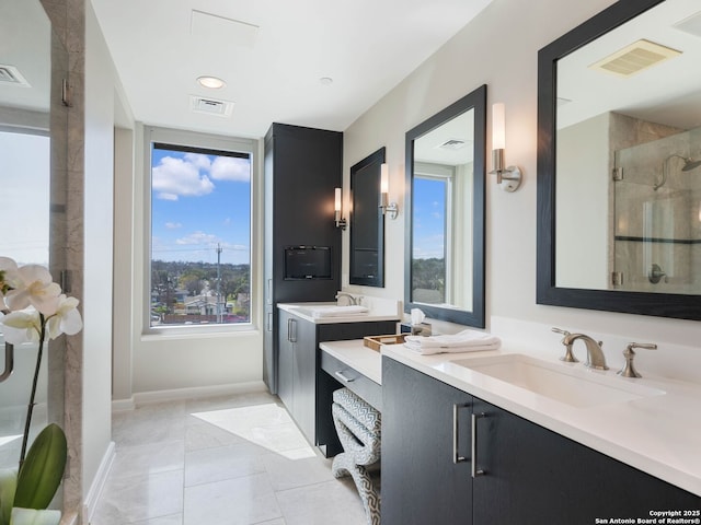 bathroom with a sink, visible vents, a shower stall, and tile patterned floors