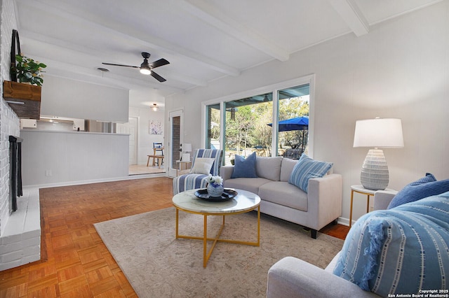 living area featuring beam ceiling, baseboards, and ceiling fan