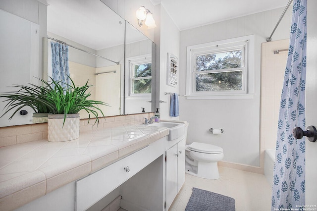 bathroom featuring tile patterned flooring, baseboards, toilet, vanity, and shower / bathtub combination with curtain