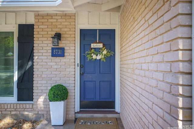 view of exterior entry with brick siding