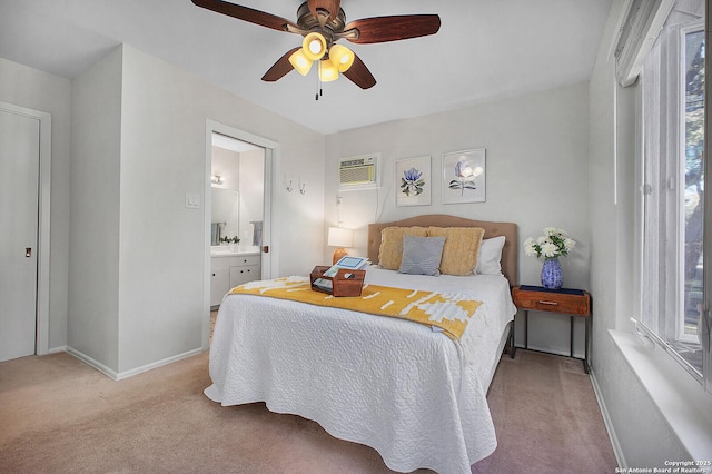 bedroom with an AC wall unit, connected bathroom, carpet, baseboards, and ceiling fan