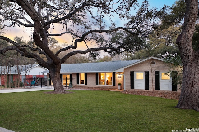 ranch-style house featuring brick siding, a chimney, and a front lawn