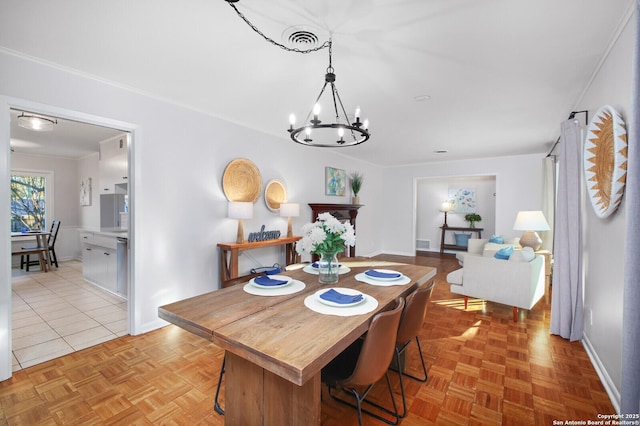 dining area featuring a notable chandelier, visible vents, and baseboards