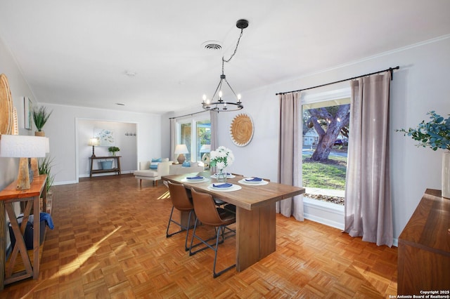 dining area featuring visible vents, baseboards, an inviting chandelier, and crown molding