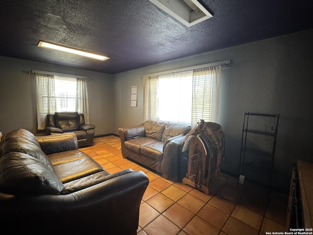 living room featuring plenty of natural light, a textured ceiling, and light tile patterned flooring