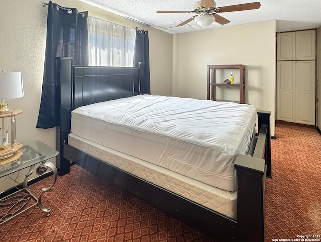 carpeted bedroom with a textured ceiling and ceiling fan