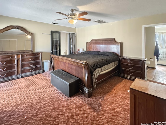 bedroom with ceiling fan, visible vents, and a textured ceiling