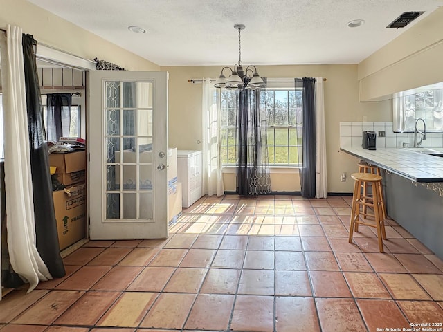 dining area with baseboards, visible vents, light tile patterned flooring, a textured ceiling, and a chandelier