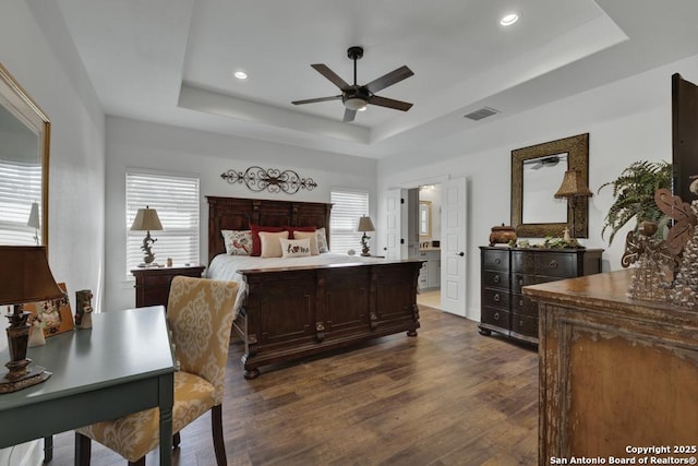 bedroom featuring visible vents, ceiling fan, a tray ceiling, recessed lighting, and dark wood-style floors