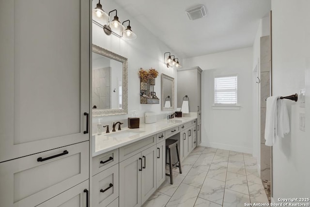 bathroom featuring a sink, visible vents, marble finish floor, and double vanity