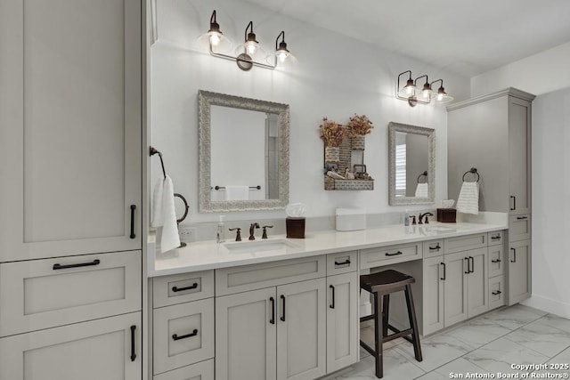 bathroom featuring a sink, marble finish floor, and double vanity