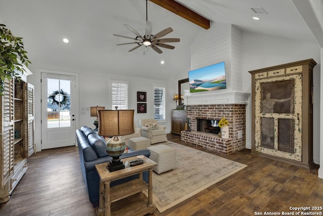 living area with beamed ceiling, high vaulted ceiling, dark wood finished floors, recessed lighting, and a brick fireplace