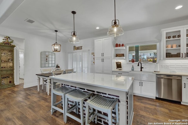 kitchen featuring dark wood-type flooring, a sink, tasteful backsplash, white cabinets, and dishwasher