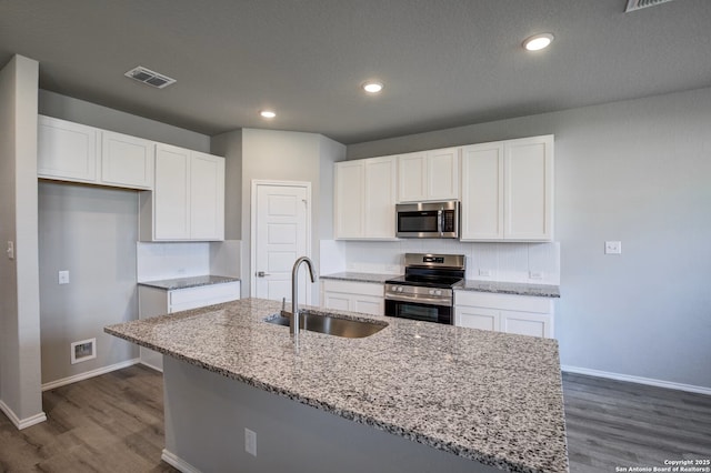 kitchen featuring light stone countertops, baseboards, a sink, stainless steel appliances, and white cabinetry