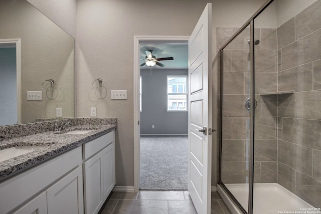 bathroom with double vanity, a stall shower, and a sink