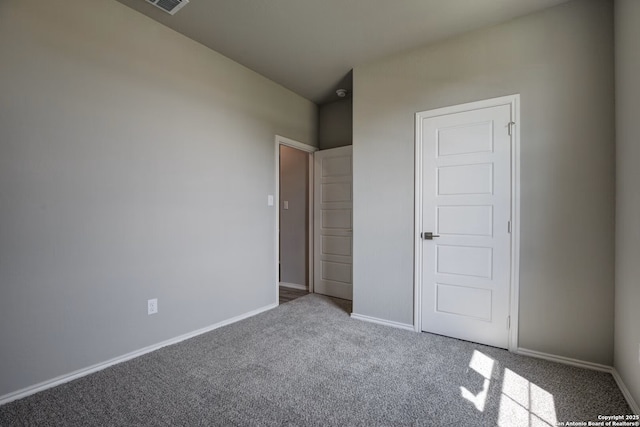 unfurnished bedroom with carpet flooring, visible vents, and baseboards