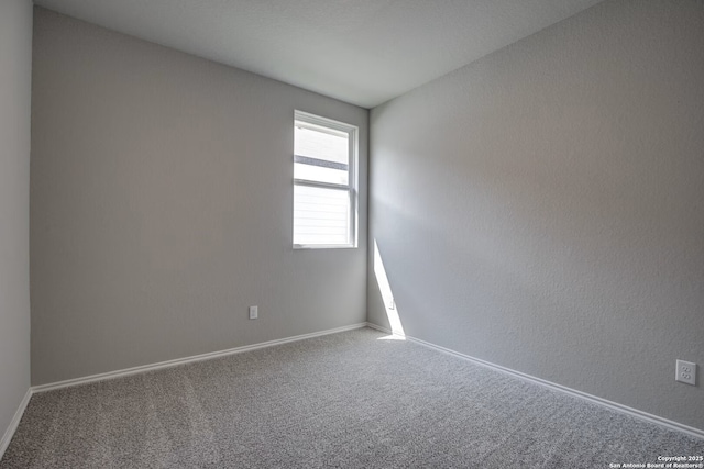 carpeted spare room with baseboards