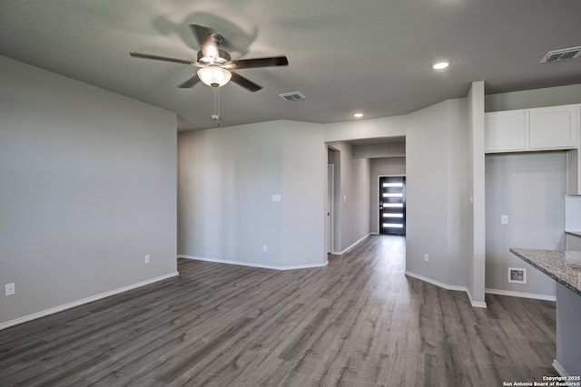 unfurnished living room featuring ceiling fan, visible vents, baseboards, and wood finished floors