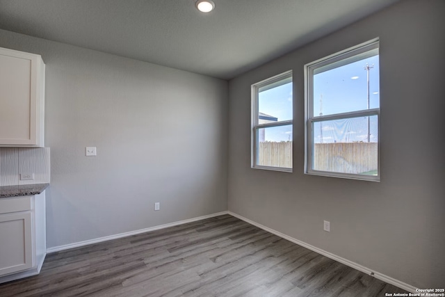 empty room featuring wood finished floors and baseboards