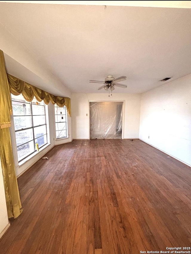 unfurnished living room with visible vents, a ceiling fan, and wood finished floors