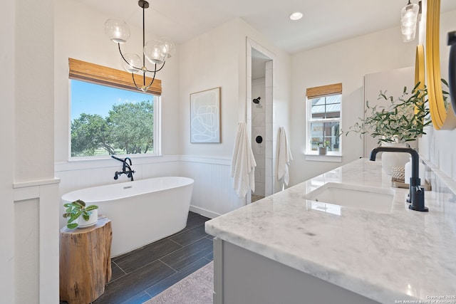 full bath with a tile shower, vanity, wainscoting, a soaking tub, and wood tiled floor