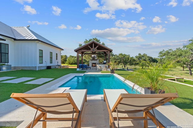 outdoor pool featuring a gazebo, a lit fireplace, a lawn, and a patio area