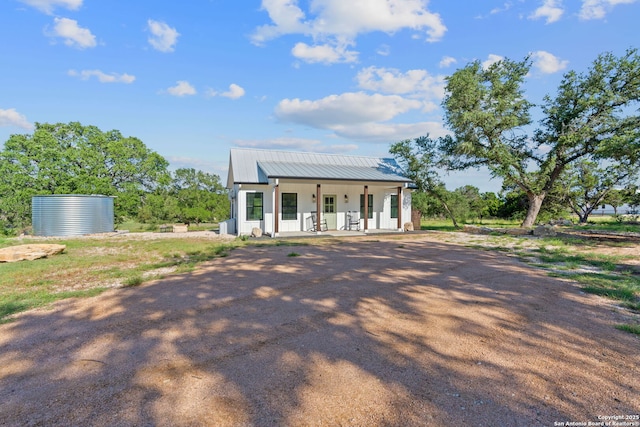 back of property with covered porch and metal roof