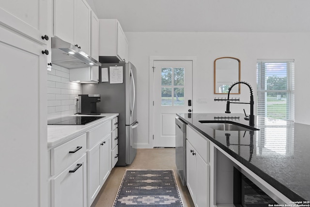 kitchen with a healthy amount of sunlight, under cabinet range hood, dishwasher, black electric cooktop, and a sink